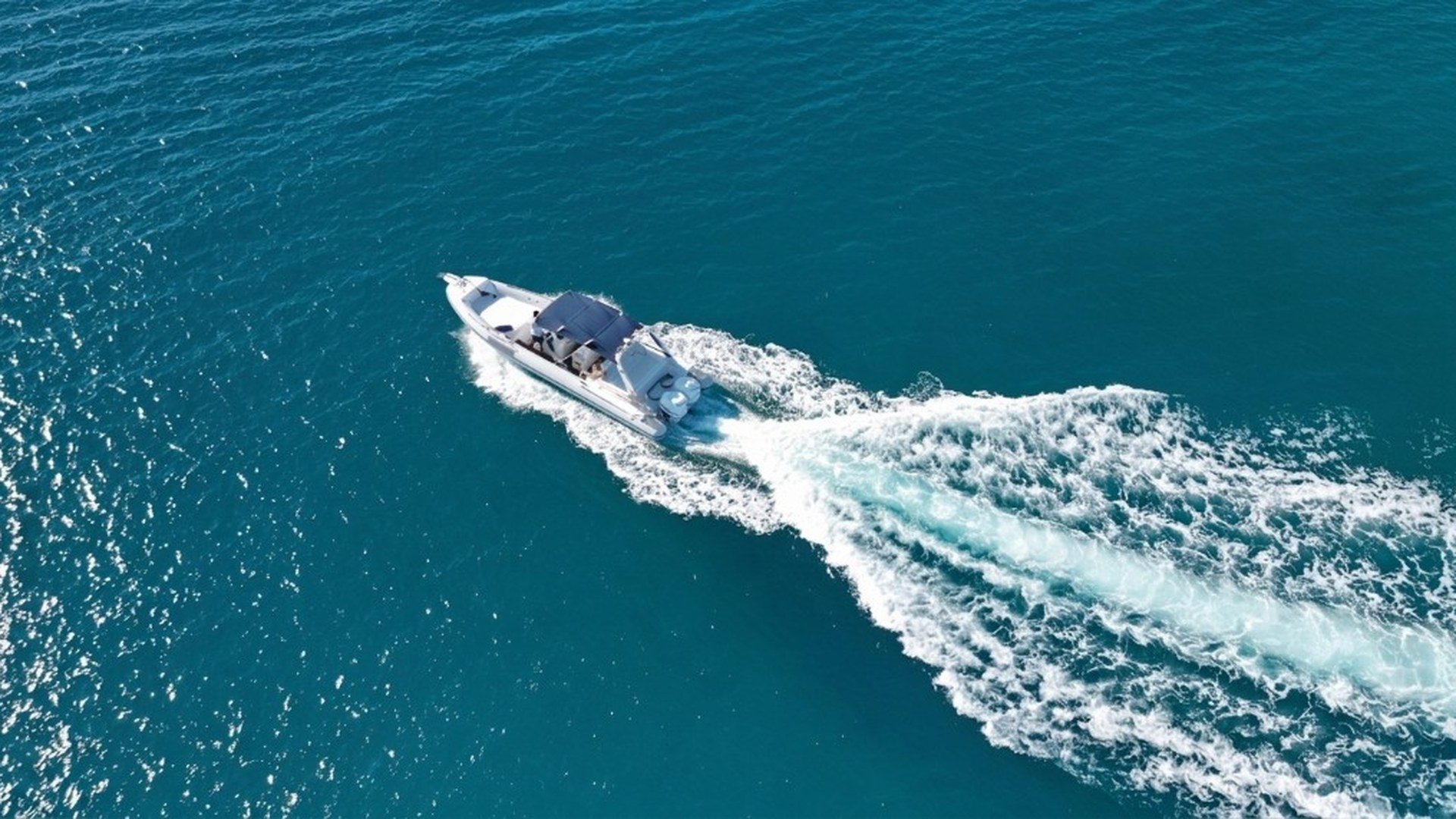 Motorboat leaving a wake across blue ocean