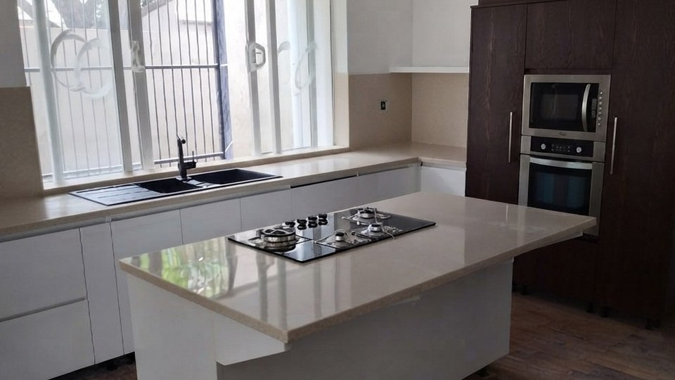 Modern kitchen with white quartz island countertop and integrated appliances